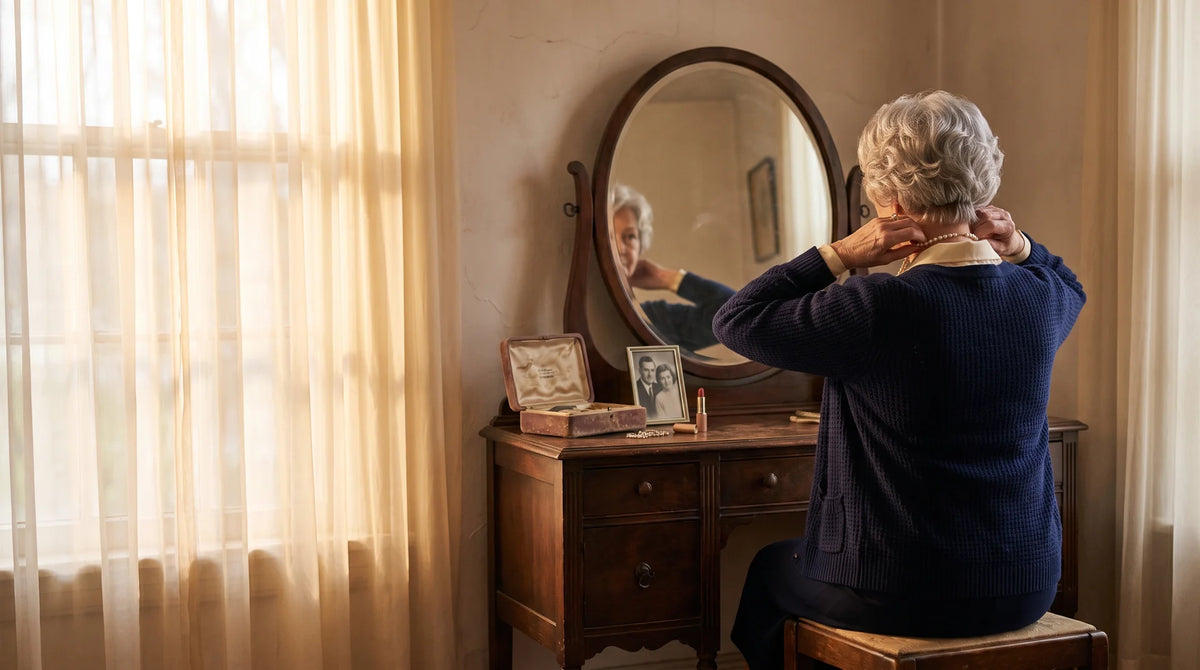 A woman at her vanity mirror fastening her pearls